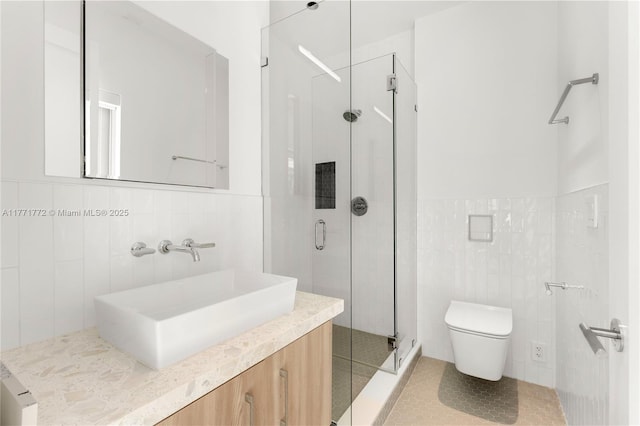 full bathroom featuring a stall shower, toilet, vanity, tile patterned flooring, and tile walls