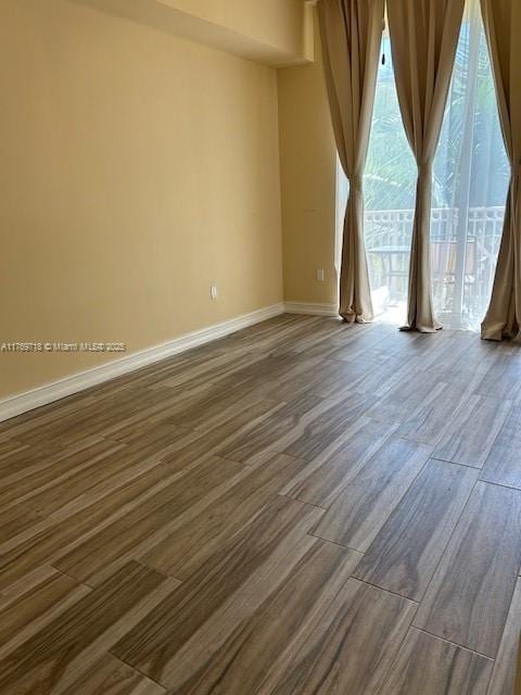 3001 NE 185th St Unit 418, Aventura, FL 33180 - spare room featuring baseboards and dark wood-style flooring