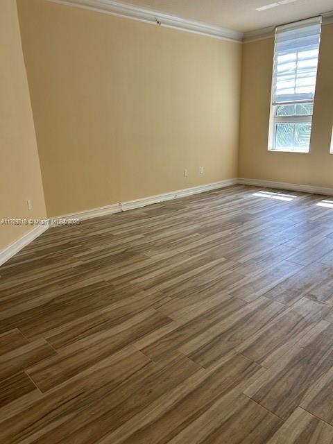 3001 NE 185th St Unit 418, Aventura, FL 33180 - empty room with ornamental molding, wood finished floors, and baseboards