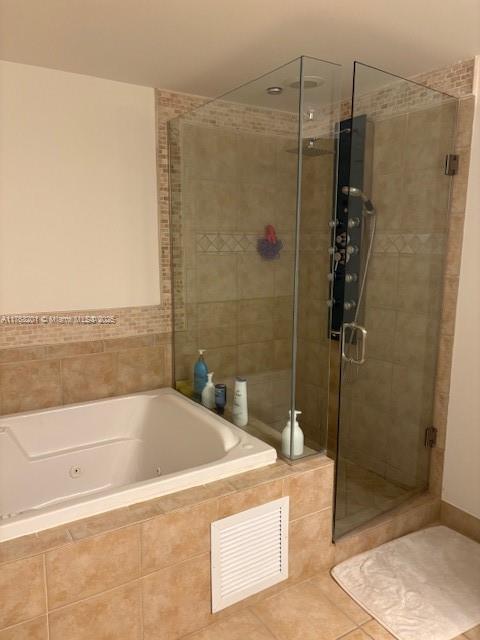 bathroom with a shower stall, visible vents, tile patterned flooring, and a jetted tub
