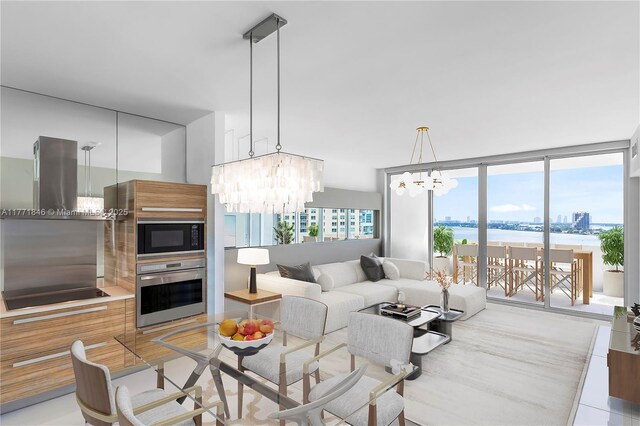 living room featuring a water view, a notable chandelier, floor to ceiling windows, and light wood-style flooring