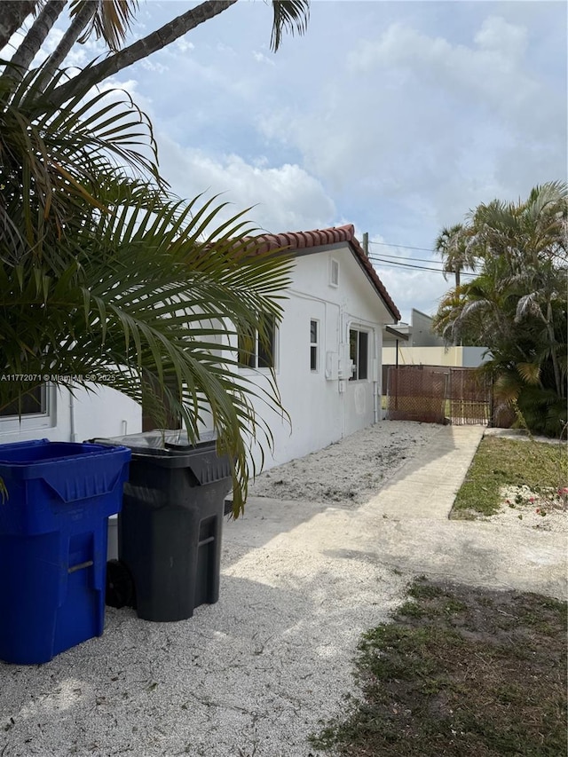 326 N 32nd Ave, Hollywood, FL 33021 - view of property exterior featuring a tiled roof, stucco siding, and fence