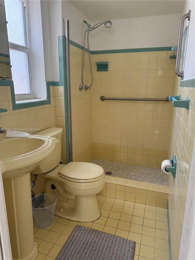 326 N 32nd Ave, Hollywood, FL 33021 - bathroom with tile patterned floors, tile walls, a stall shower, toilet, and wainscoting