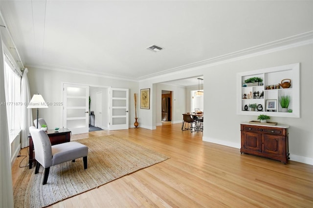 1259 NE 98th St, Miami Shores, FL 33138 - living area featuring crown molding, built in features, light wood finished floors, and visible vents