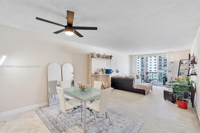 dining space featuring expansive windows, a textured ceiling, baseboards, and a ceiling fan