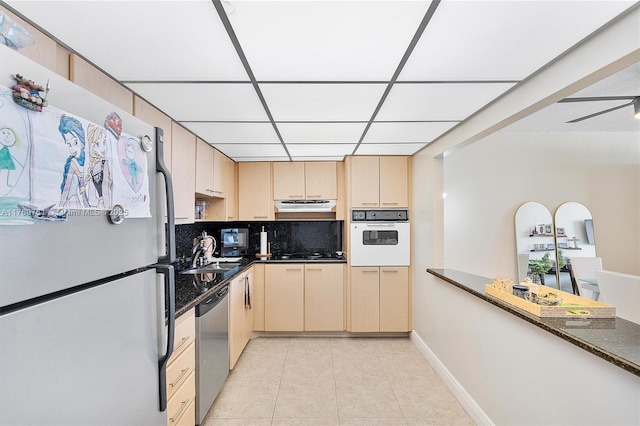 19390 Collins Ave Unit 804, Sunny Isles Beach, FL 33160 - kitchen featuring white appliances, under cabinet range hood, light tile patterned floors, light brown cabinetry, and a paneled ceiling