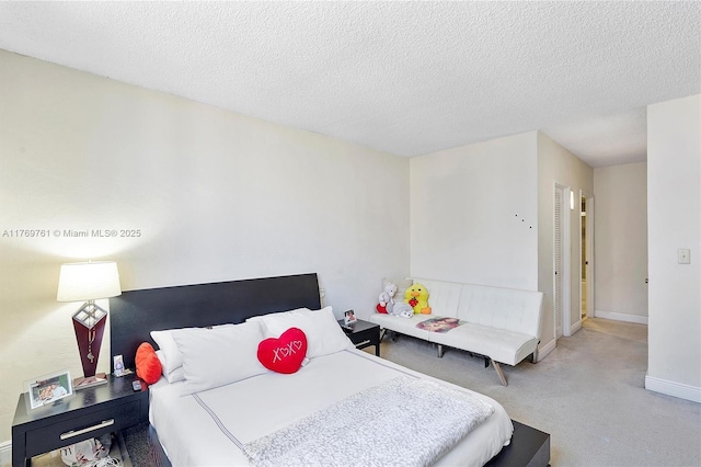 carpeted bedroom with baseboards and a textured ceiling