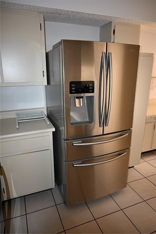 1170 N Hiatus Rd Unit 1170, Pembroke Pines, FL 33026 - kitchen with stainless steel fridge, light tile patterned flooring, light countertops, white cabinetry, and a textured ceiling