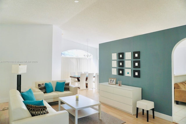 12268 SW 145th St, Miami, FL 33186 - living area featuring arched walkways, a chandelier, light wood finished floors, and vaulted ceiling