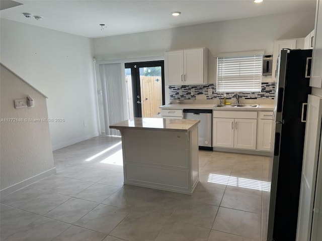 kitchen featuring light countertops, a sink, backsplash, white cabinetry, and appliances with stainless steel finishes