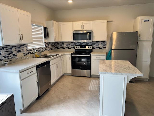 kitchen featuring backsplash, light countertops, a sink, and stainless steel appliances