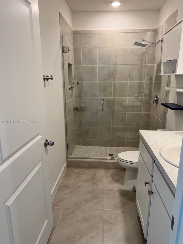 full bathroom featuring a stall shower, tile patterned floors, toilet, and vanity