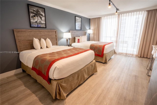 19201 Collins Ave Unit 425, Sunny Isles Beach, FL 33160 - bedroom with light wood-style floors, ornamental molding, and track lighting