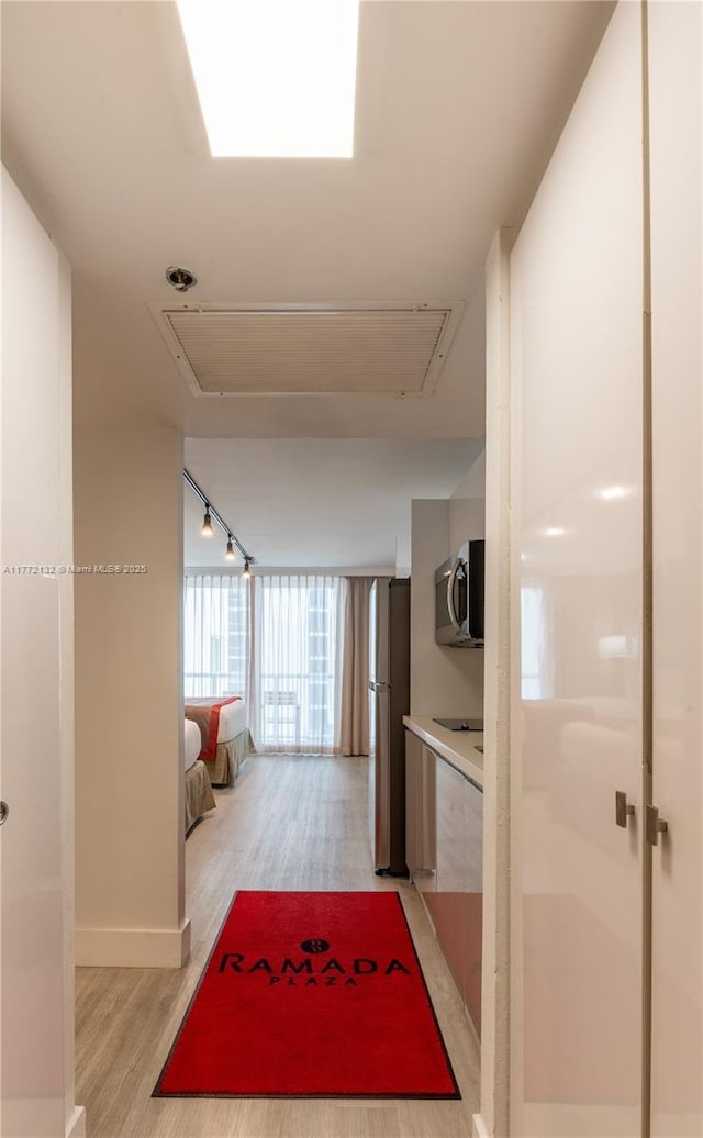 19201 Collins Ave Unit 425, Sunny Isles Beach, FL 33160 - corridor with baseboards, light wood-style flooring, and attic access