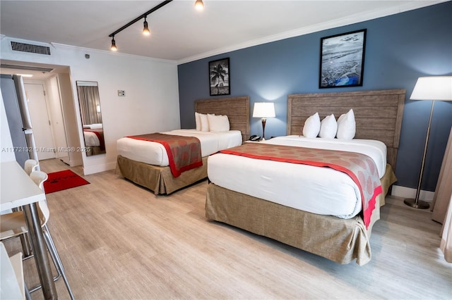 19201 Collins Ave Unit 425, Sunny Isles Beach, FL 33160 - bedroom with track lighting, baseboards, light wood-type flooring, visible vents, and ornamental molding