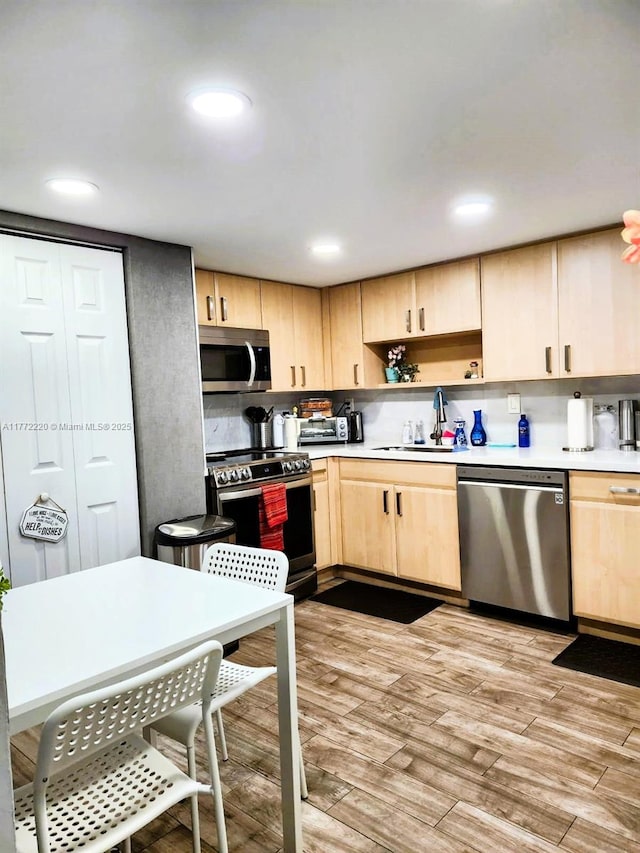 575 NW 98th Ave, Plantation, FL 33324 - kitchen featuring stainless steel appliances, light brown cabinetry, a sink, light countertops, and light wood finished floors