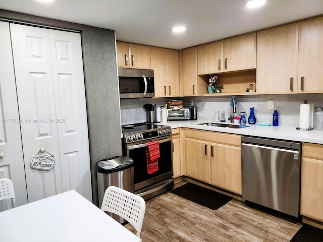 575 NW 98th Ave, Plantation, FL 33324 - kitchen with light brown cabinetry, appliances with stainless steel finishes, a sink, light countertops, and light wood-type flooring