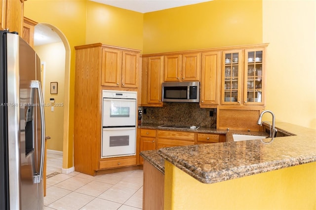 3091 SW 195th Ter, Miramar, FL 33029 - kitchen with decorative backsplash, light tile patterned flooring, arched walkways, a sink, and stainless steel appliances