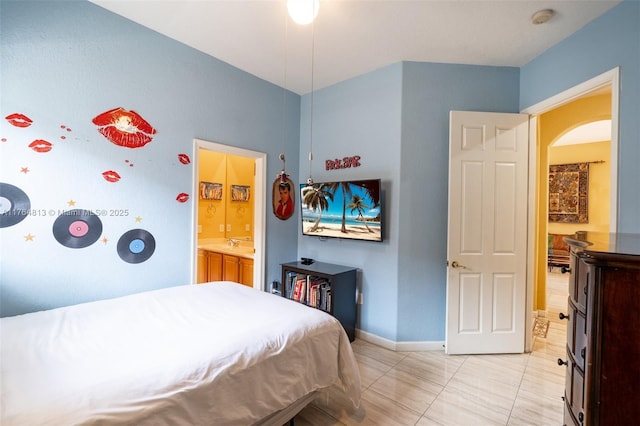 3091 SW 195th Ter, Miramar, FL 33029 - bedroom featuring arched walkways, baseboards, light tile patterned floors, and ensuite bath
