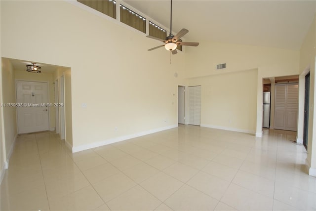 empty room with light tile patterned flooring, baseboards, ceiling fan, and visible vents