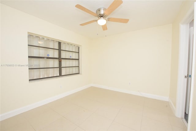 empty room with a ceiling fan and baseboards
