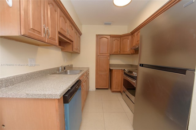 kitchen with under cabinet range hood, a sink, light tile patterned flooring, visible vents, and appliances with stainless steel finishes