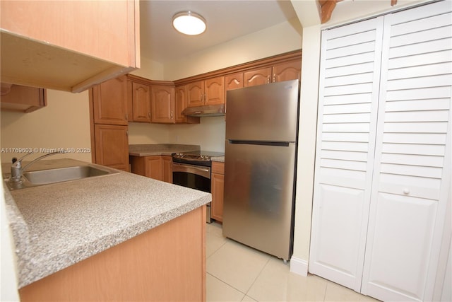 kitchen with light countertops, stainless steel appliances, under cabinet range hood, a sink, and light tile patterned floors