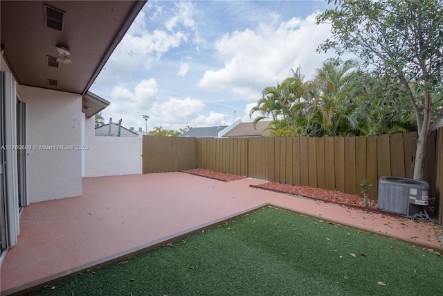 view of yard featuring a patio, visible vents, central air condition unit, and a fenced backyard