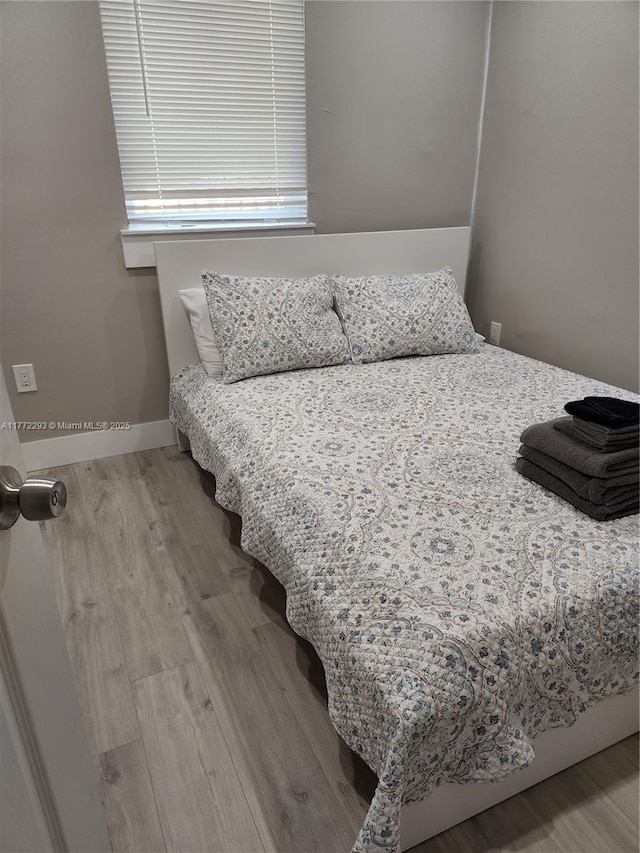 bedroom featuring baseboards and wood finished floors