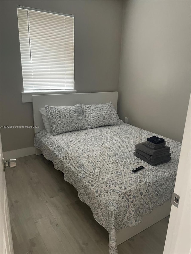 bedroom featuring baseboards and wood finished floors