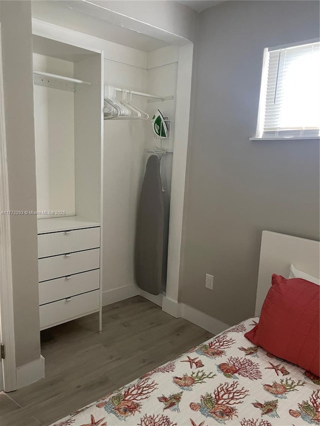 bedroom with a closet, baseboards, and wood finished floors
