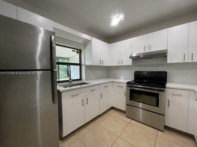 kitchen with stainless steel appliances, under cabinet range hood, light tile patterned floors, a sink, and light countertops