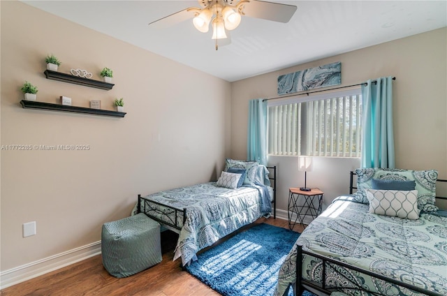 bedroom featuring baseboards, wood finished floors, and a ceiling fan