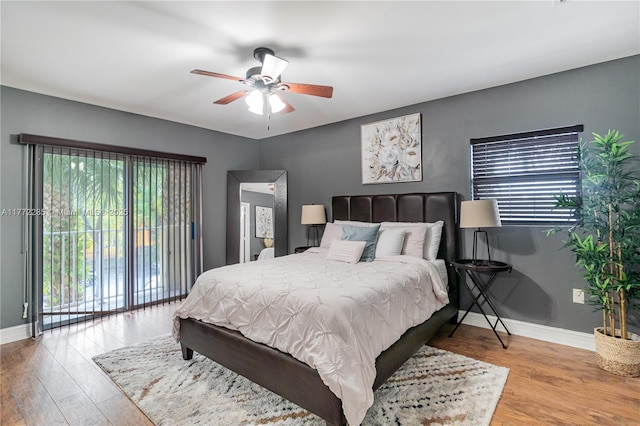 bedroom featuring access to exterior, baseboards, ceiling fan, and wood finished floors