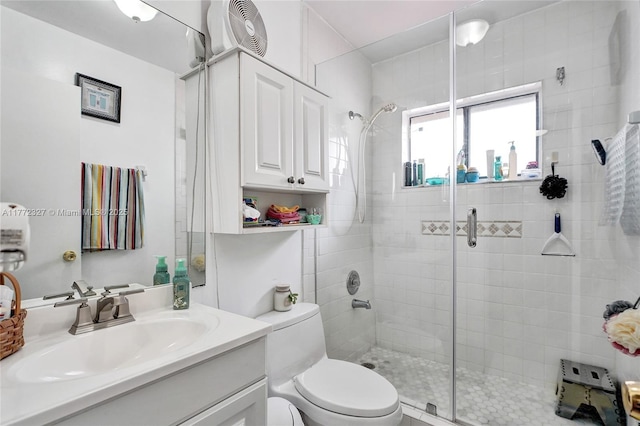 bathroom featuring vanity, toilet, and a stall shower