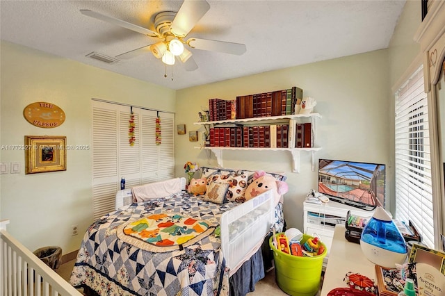 bedroom featuring a ceiling fan, visible vents, and a closet
