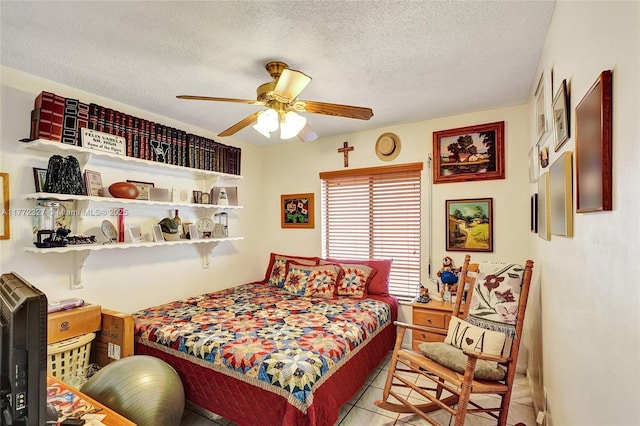 bedroom with a textured ceiling, ceiling fan, and light tile patterned flooring