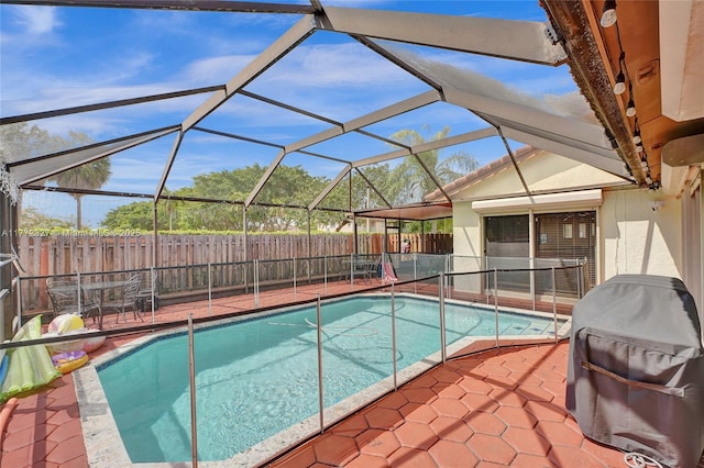 view of swimming pool with a patio area, a fenced backyard, a fenced in pool, and glass enclosure