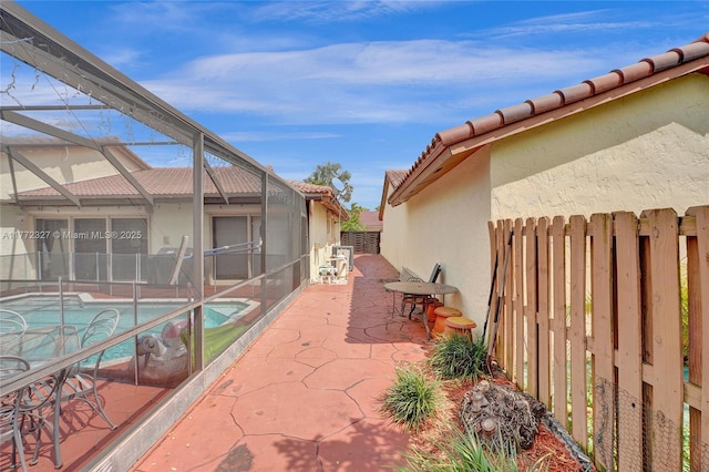 view of patio featuring a fenced in pool, a lanai, and fence