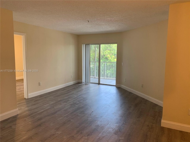 empty room with a textured ceiling, dark wood-style flooring, and baseboards