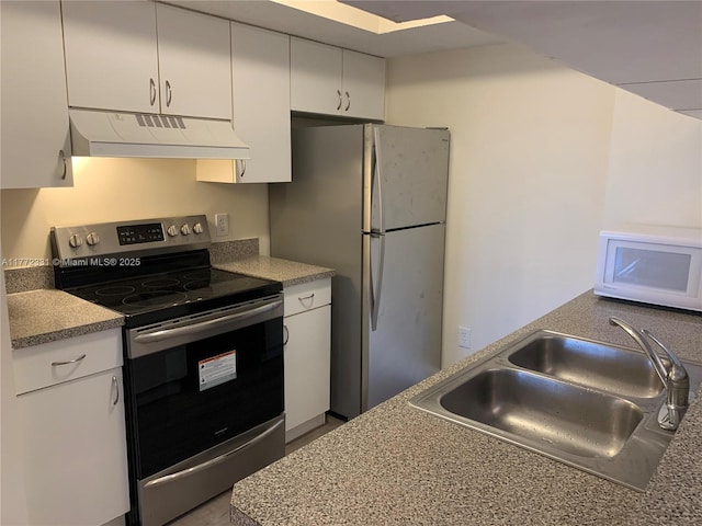 kitchen featuring under cabinet range hood, appliances with stainless steel finishes, a sink, and white cabinetry