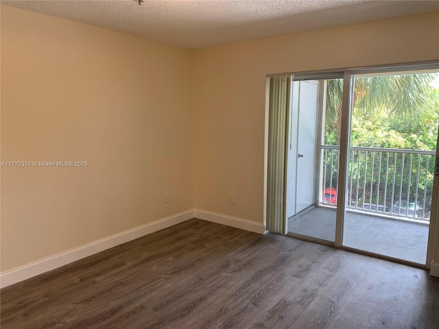 empty room featuring dark wood-style floors and baseboards