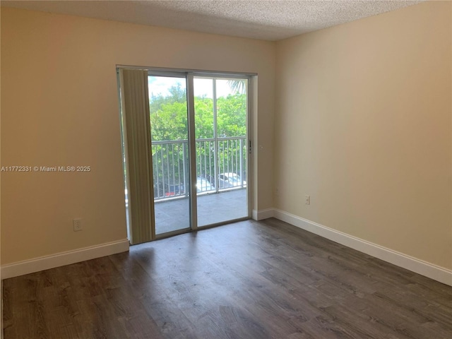 unfurnished room featuring dark wood finished floors, baseboards, and a textured ceiling