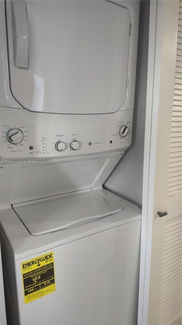 washroom featuring stacked washer and clothes dryer and laundry area