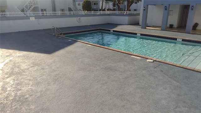 community pool featuring fence and a patio