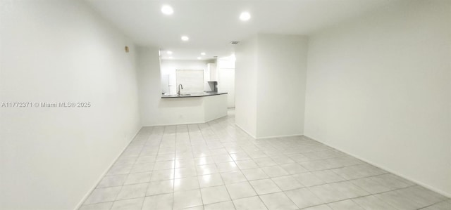 unfurnished room featuring recessed lighting, a sink, and light tile patterned floors