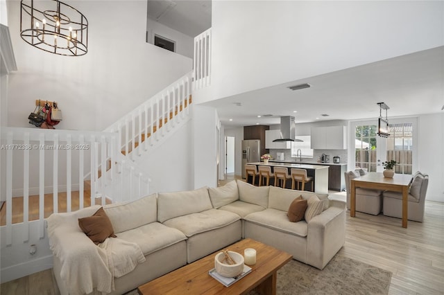 10724 NW 12th Mnr, Plantation, FL 33322 - living area with an inviting chandelier, light wood-style floors, visible vents, and stairway