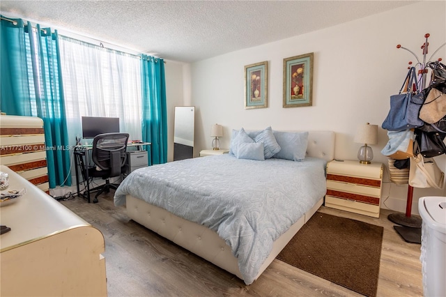 bedroom featuring a textured ceiling and wood finished floors