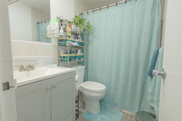 full bath featuring tile walls, curtained shower, toilet, and vanity