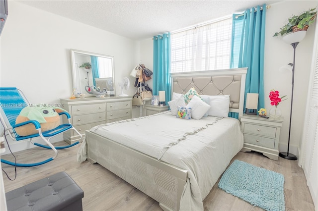 bedroom featuring wood finished floors and a textured ceiling